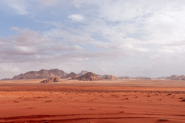 A desert landscape with a cloudy sky in the background