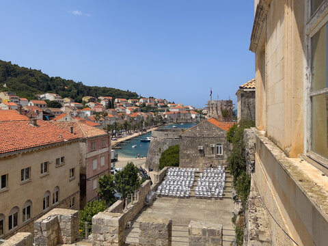 Korcula, Croatia - June 30, 2024: Looking East from Southern gate upon corner fortification with short docks and the neighborhood housing behind the Put Svetog Nicole boardwalk and road. Moreska theat