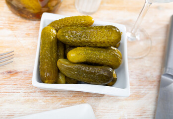 Pile of pickled cucumbers served on table and ready to eat.