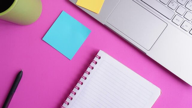 Top view of person placing sticky notes near laptop and notebook, on desk