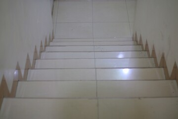 A plain, white staircase with a tiled floor.