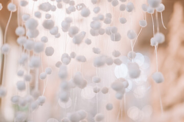 White Texture with Floating Elements. White pompoms Wallpaper.Delicate Pom-Pom Decoration.Soft background in white and beige tones.Abstract White Decoration with Bokeh Background 