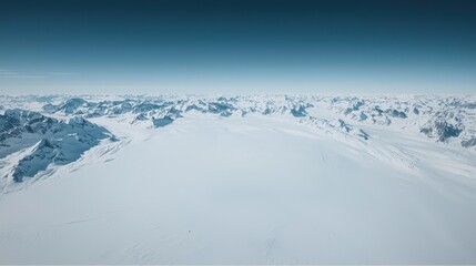 Serene Aerial View of Snow-Covered Mountain Range Under a Clear Blue Sky