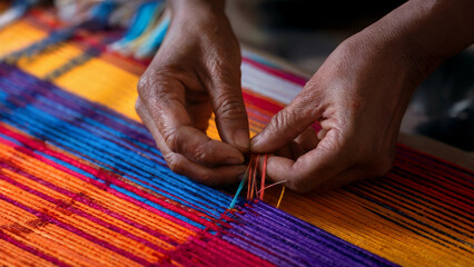 Obraz premium Close-up of hands weaving colorful threads