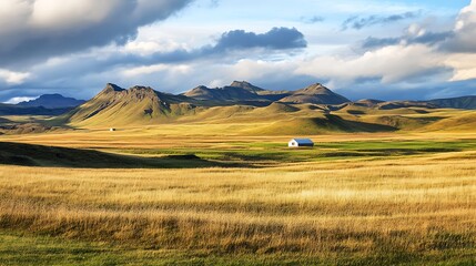 Fototapeta premium Icelandic Landscape with Mountains and Farmhouse. Scenic View of Golden Grassland.