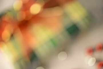  Blurred abstract holiday scene with warm red, green, and golden tones.
