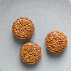 homemade mooncakes on a grey plate, top view of baked mooncakes on a plate, process of making mooncakes for Lunar New Year and mid autumn festival