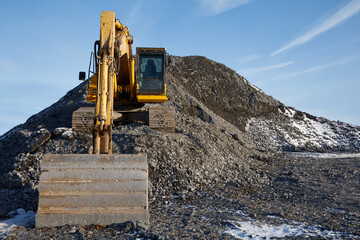 Excavator Shovel at Construction Site on Gravel Pile Front View