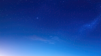 Wide-angle view of a serene starry sky with a blue gradient background, captured at night with bright stars and detailed clarity, evoking a calm and tranquil atmosphere.