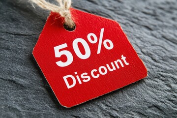 Bright Red Discount Tag with 50 Percent Off on Dark Stone Background