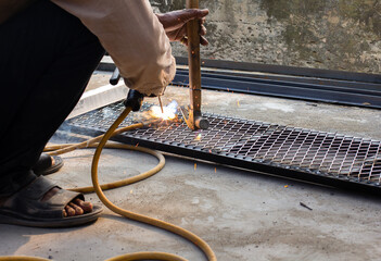 Welder is welding add joint at a construction site weld metal structures of  Steel frames and grids for use in construction.