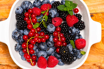 Mix of wild forest berry fruits. Blueberry, raspberry, blackberry. Healthy fresh berries background. Berries as background. Summer berries pattern.