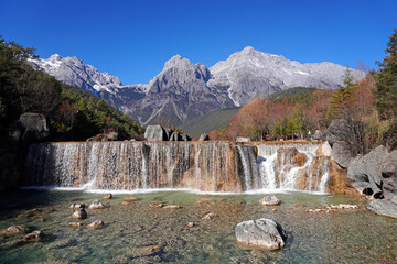Waterfall at Baishui River is a short tributary of the Yangtze River in Lijiang, Yunnan Province, China. The river has its source on the eastern flanks of Jade Dragon Snow Mountain 