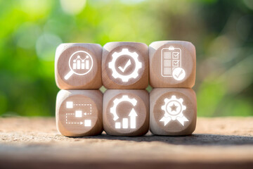 Wooden blocks displaying quality control icons, symbolizing efficiency and standards in business and manufacturing processes.