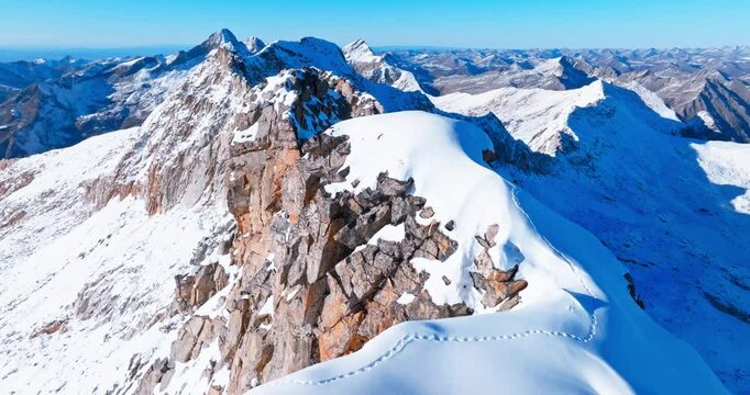 Aerial photography of snow-capped mountains, with a trail of footprints on the top. Dagu glacier at Sichuan China