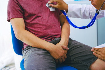 A man suffering from urinary tract infections visits a doctor at the examination table in a hospital.symptoms, discusses benign prostatic hyperplasia (BPH), and provides advice and treatment