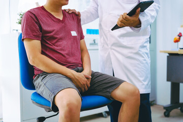 Obraz premium A man suffering from urinary tract infections visits a doctor at the examination table in a hospital.symptoms, discusses benign prostatic hyperplasia (BPH), and provides advice and treatment
