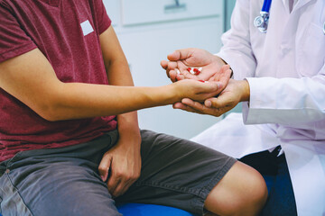 A man suffering from urinary tract infections visits a doctor at the examination table in a...