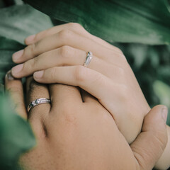 Close up of couple's hands with engagement rings