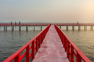Obraz premium Red Bridge is A 700-meter long red wooden bridge, Samut Sakhon, dolphin viewing point, sunset, mangrove forest, fresh air located in Tambon Phanthai Norasing