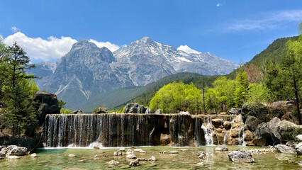 Blue Moon Valley showing waterfall,  clear blue lake and stunning mountain backdrop of Jade Dragon Snow Mountain, Lijiang, China © Y.a.o.W