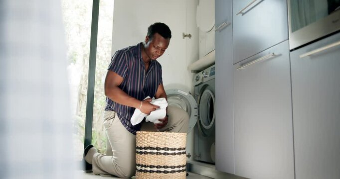 Laundry, man and loading clothes in washing machine for housekeeping, fresh linen and cleaning routine. Hygiene, black person and fabric in appliance for domestic chores and housework in washroom