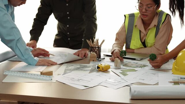 Professional engineer measuring the blueprint. Professional engineer working architectural project at studio on a table with yellow helmet and architectural equipment scatter around. Delineation.