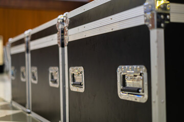 Stacked black flight cases in a large room preparing to set up for concert or large event