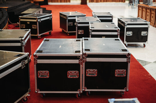 Stacked black flight cases in a large room preparing to set up for concert or large event