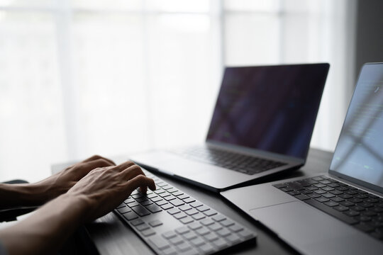 Asian man software engineer Working on Computer at office desk for writing program code IT Software Engineer finding errors tech support devops creating digital