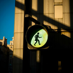 Pedestrian Traffic Light Displaying Walking Symbol in Urban Street Setting