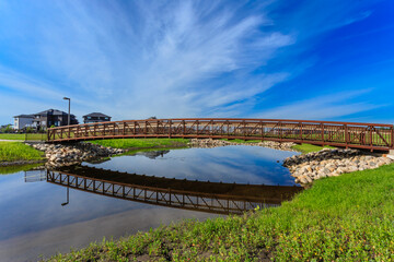 A bridge spans a body of water, with a reflection of the bridge in the water