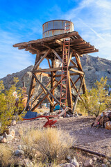 A rusty water tower sits in the desert