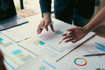 Business team analyzing financial charts and graphs, discussing company strategy and planning for future success