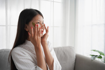 Asian woman in bathrobe applying skincare, take care of your facial skin