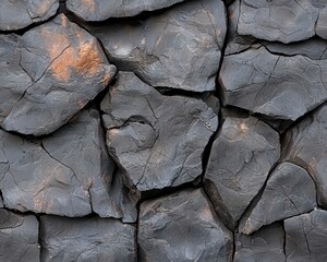 Close-up of textured dark volcanic rock, showcasing intricate cracks and natural formations.