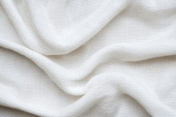 A close-up view of soft, textured white fabric draped elegantly, showcasing its gentle folds and lightness.