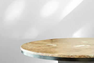 Round marble table top with abstract shadow drop on white wall background for mockup product display