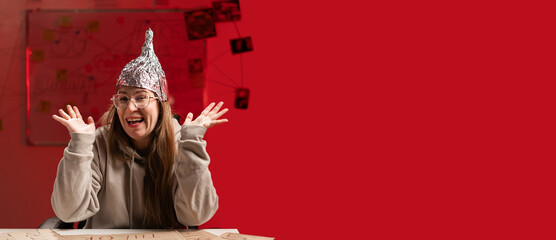 Female conspiracy theorist in protective foil cap and glasses debunks myths, crazy emotion and...