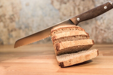 fresh homemade bread cut into thick slices, bread knife, crispy bread, kitchen, wooden table