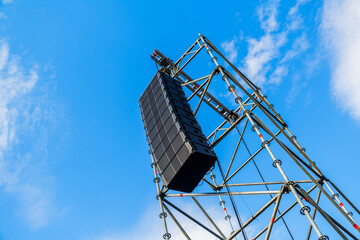 Overhead stage rigging equipment  Concert stage with outdoor lighting and sound equipment on cloudy...