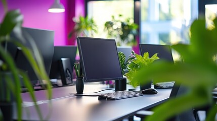 Modern office workspace with computers and plants.