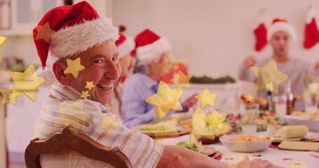 Caucasian family enjoying Christmas dinner, grandfather wearing Santa hat