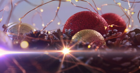 Image of glowing lights moving over christmas baubles and decorations