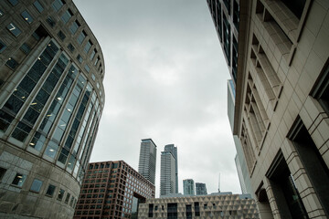 Fototapeta premium Modern skyscrapers reaching for the cloudy sky in canary wharf, london