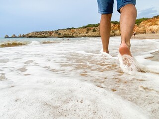 Healing walk on the beach with the waves of the sea touching the feet