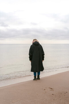 Young woman on the shore of the cold Baltic sea in winter in Latvia