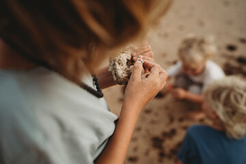 Close up of child hands full of sand holding shells