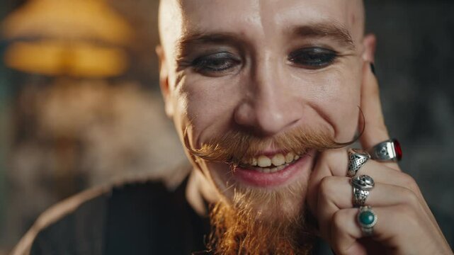 Portrait of attractive middle-aged man using computer, closeup of smiling face. Male person shopping online from home, browsing internet, using social networks, extravagant male makeup, hipster style
