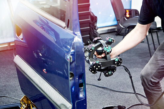 Engineer man with tracking 3D scanner and cars door